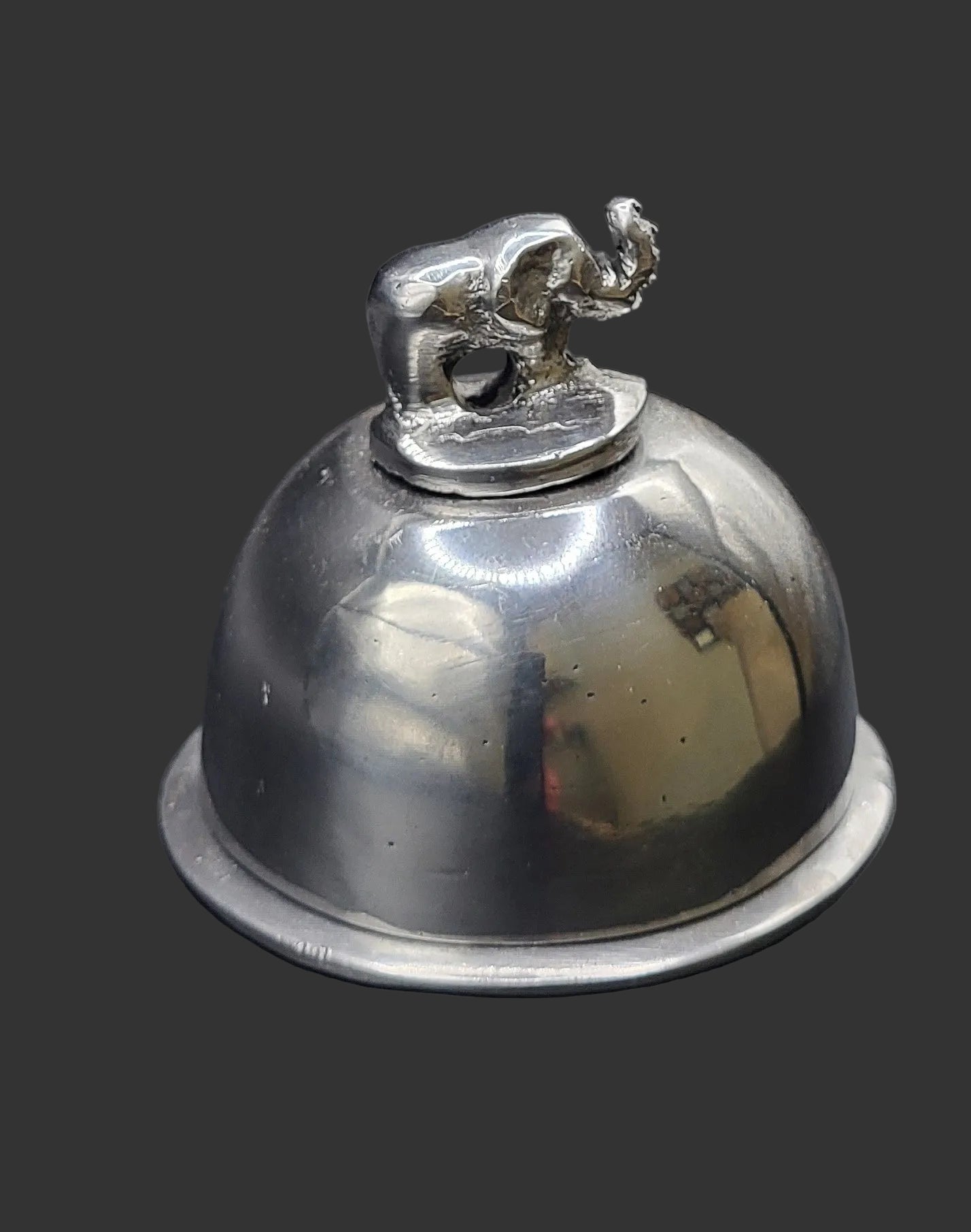 Silver bell with a small elephant on top