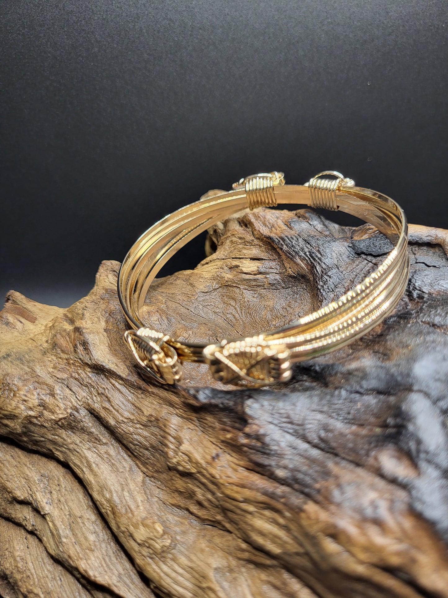 Elephant Hair Bangle 4 Knot 3 Gold Strand Side View On Wood